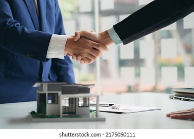 Real estate professionals and clients discussing home purchases, insurance or real estate loans. Home sales agents sit at the office with new homebuyers in the office - Shutterstock ID 2175050111
