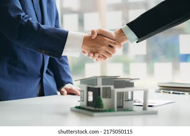 Real estate professionals and clients discussing home purchases, insurance or real estate loans. Home sales agents sit at the office with new homebuyers in the office - Shutterstock ID 2175050115