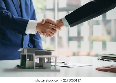 Real estate professionals and clients discussing home purchases, insurance or real estate loans. Home sales agents sit at the office with new homebuyers in the office - Shutterstock ID 2175050117