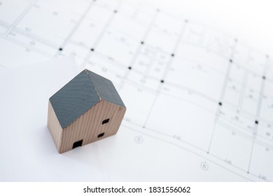 Real Estate And Property, Architecture, Building, Construction Concept - Tiny House Model On An Architect's Desk