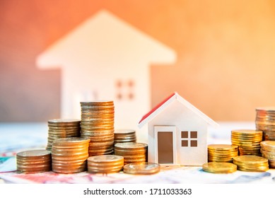 Real Estate Or Property Investment. Home Mortgage Loan Rate. Saving Money For Retirement Concept. Coin Stack On International Banknotes With House Model On Table. Business Growth Background