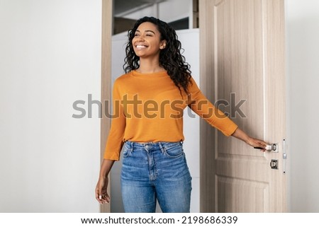 Real Estate Purchase. Happy Black Young Woman Entering Apartment Opening Entry Door Looking Aside At Living Room. New House, Property Ownership Concept Foto d'archivio © 