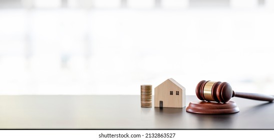 Real estate sale auction concept - gavel, house model and stack of coins on wooden table, banner background. - Shutterstock ID 2132863527