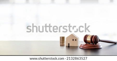 Real estate sale auction concept - gavel, house model and stack of coins on wooden table, banner background.