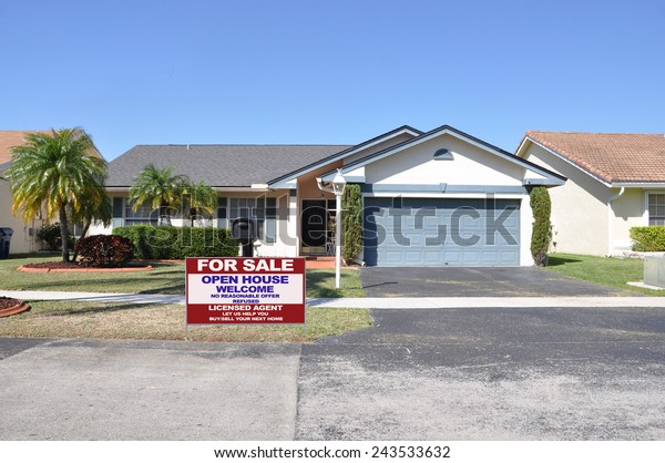 Real\
estate for sale open house welcome sign Suburban back split style\
home residential neighborhood clear blue sky\
USA