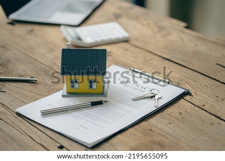 Real estate sales office with example of a house on a businessman's desk.