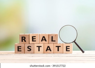 Real Estate Search Sign With A Magnifying Glass On A Table