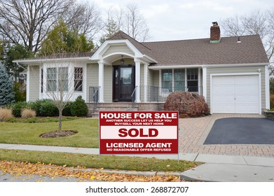 Real estate sold (another success let us help you buy sell your next home) sign Beautiful Suburban Tan Ranch Home Autumn Season Residential neighborhood USA