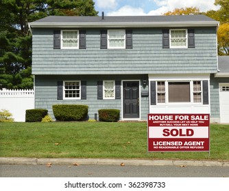 Real estate sold (another success let us help you buy sell your next home) sign Suburban High Ranch Style Home autumn fall day sunny residential neighborhood USA blue sky clouds