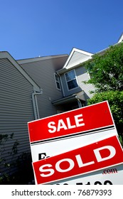 Real Estate Sold Rider Red Insert On A Realtor Advertising For Sale Sign In Front Of A House With Blue Sky