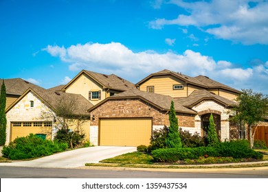 Real estate suburb development in Austin Texas nice new builds community neighborhood in new suburbia homes and houses with two car garage and nice trees and landscaping