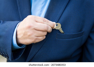Real estate transactions. The real estate agent. The concept of private property. Businessman in a business suit with private house key in the pocket. House and keys, the idea of security.