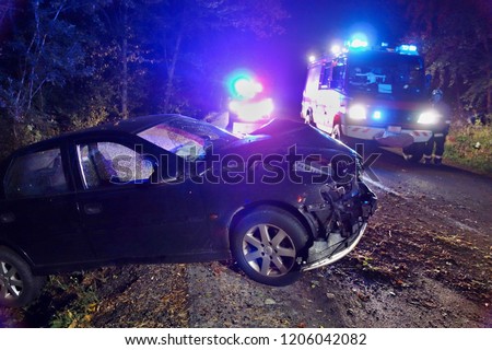 Real event. Car accident. The car crashed at night on a wet road . Car accident over raining day in autumn time. Rescuers help with car accident, ambulance, fire and police.