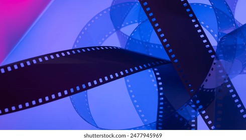 real film strip illuminated with multi-colored light for a cinematic background with film. film production announcements tickets cards flyers premieres series scripts concept. - Powered by Shutterstock
