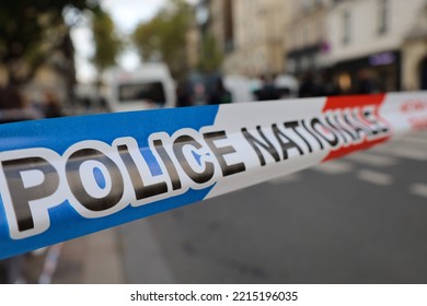 real french police tape ribbon with blurry street crime scene background , do not cross investigation scene