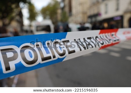 real french police tape ribbon with blurry street crime scene background , do not cross investigation scene