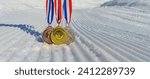 real Gold, silver and bronze medals hanging on red ribbons isolated lying on prepared, new snow ski slope