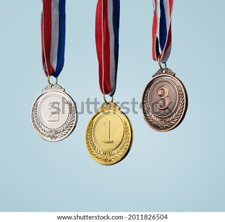 real Gold, silver and bronze medals hanging on red ribbons isolated on white background. 