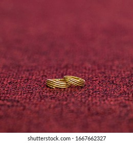 Real Gold Swirl Engagement Ring On Maroon Background