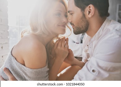 Real love. Beautiful young couple bonding and smiling while sitting in the bedroom - Shutterstock ID 1021844050