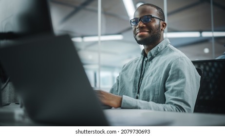 Real Office: Professional Black IT Programmer Working On Desktop Computer. Male Website Developer And Software Engineer Developing App, Video Game. Progressive, Innovative And Inspirational Person