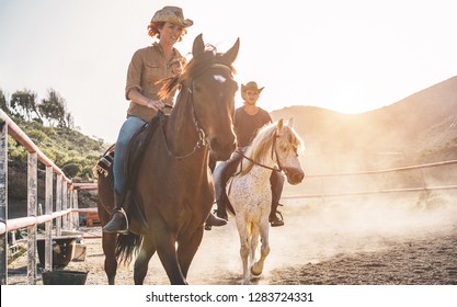 Real people riding horses inside corral - Wild couple having fun in equestrian ranch  - Training, culture, passion, excursion, healthy lifestyle, sport concept - Focus on man face - Powered by Shutterstock