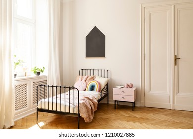 Real Photo Of A Child Bedroom Interior With A Single Bed, Bedside Table, Window And Blackboard On A Wall