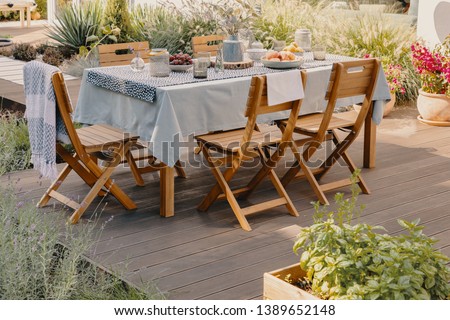 Real photo of a dining table with wooden chairs set on the terrace