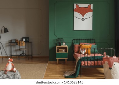 Real photo of a fox painting hanging on a green wall with molding, above black, metal bed in a kid's room interior