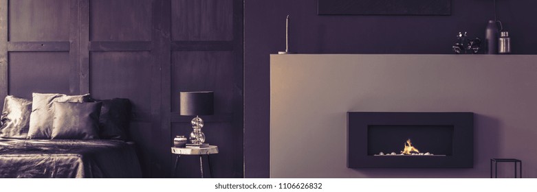 Real Photo Of A Luxurious Bio Fireplace, Silk Sheets And Elegant Decorations In A Beautiful Dark Purple Bedroom Interior