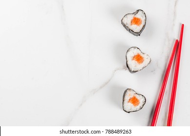 Real sushi set for valentine's day in form of hearts. White marble background copy space top view