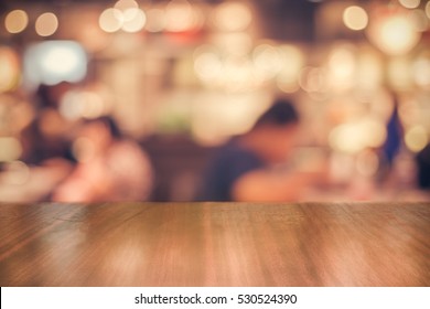 Real Wood Table With Light Reflection On Scene At Restaurant, Pub Or Bar At Night. Blurred Background For Product Display Or Montage Your Products With Several Concept Idea And Any Occasion.