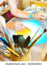 Real work studio of the painter. Man is creating picture. Artist concept. Creative atmosphere. Paint palette knife. Brushes.