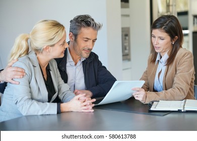 Real-estate agent reading terms of contract to clients  - Shutterstock ID 580613788