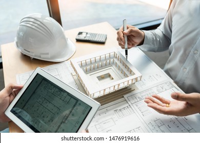 Real-estate concept, Two engineer and architect discussing blueprints data working and digital tablet on construction building project