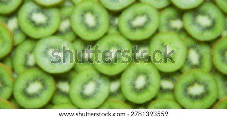 Realistic blurred kiwi slice pattern with overhead composition and organic texture. Food background ideal for commercial applications.