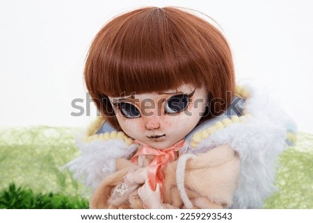 realistic doll toy scary portrait in fashion clothes in green background