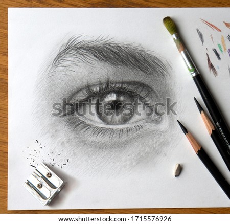 Realistic drawing of a human eye with art materials