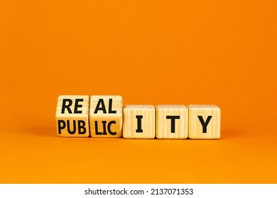 Reality or publicity symbol. Turned wooden cubes and changed the word Publicity to Reality. Beautiful orange table orange background. Business reality or publicity concept. Copy space.