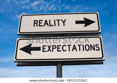 Reality vs expectation. White two street signs with arrow on metal pole with word. Directional road. Crossroads Road Sign, Two Arrow. Blue sky background. Two way road sign with text.