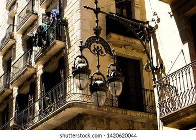 Really Beautiful And Old Street Lamp With Three Big Light Bulbs Hanging At The Corner Of A House In The Wonderful Streets Of Barcelona, Spain.