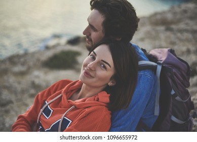 I Am Really Happy. Portrait Of Glad Young Woman Looking At Camera And Smiling. Man Is Hugging Her With Love While Viewing Sea Landscape