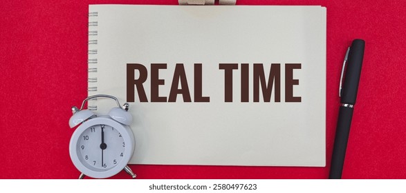 Real-Time Data Analysis on Notebook with Alarm Clock and Pen on Red Background. 