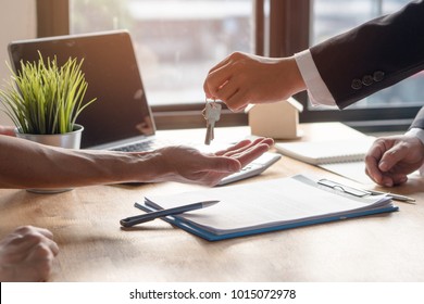 Realtor agent giving a key of apartment to new owner after signed lease agreement. - Shutterstock ID 1015072978