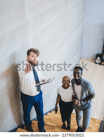 Realtor pointing at camera while showing flat to couple