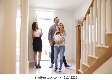 Realtor Showing Young Family Around Property For Sale