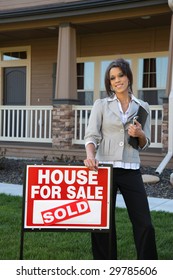 Realtor Standing In Front Of Home With SOLD Sign