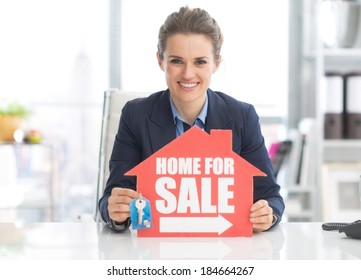 Realtor Woman Showing Keys And Home For Sale Sign