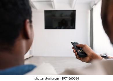 Rear Back View Of African American Man And Woman Watching Tv, Guy Holding Remote Control, Changing Channels, Family Looking At Black Blank Television On Wall, Isolated Empty Monitor, Selective Focus