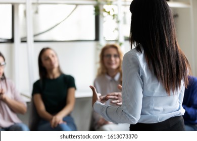 Rear back view female african ethnicity participant at group rehab session telling story share personal problem with associates or corporate staff gathered together listening business coach at seminar - Shutterstock ID 1613073370